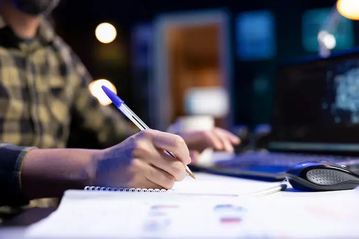 Surveyor digitally mapping land using computer and notebook.